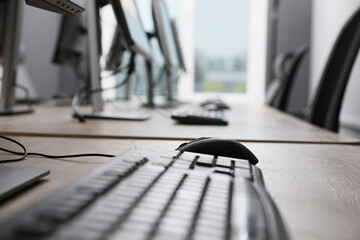 Many modern computers in open space office, focus on keyboard