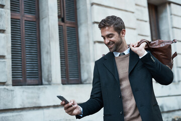 Staying in touch even when hes out and about. Cropped shot of a handsome businessman using his cellphone while about town.