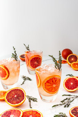 Fruity refreshing drink with blood oranges and ice and thyme, delicious sweet juice