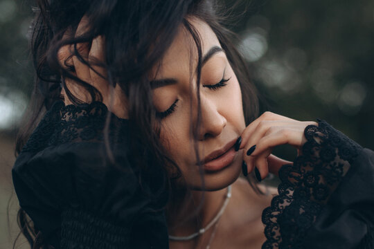Close-up of beautiful young asian woman with stylish boho accessories on natural background