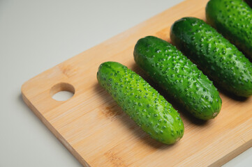 juicy ripe cucumber in half lies on a wooden cutting board, top view