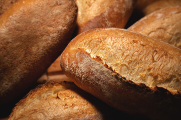 Sourdough bread close-up. Freshly baked round bread with golden crust on bakery shelves. The context of a German bakery with a rustic assortment of bread.