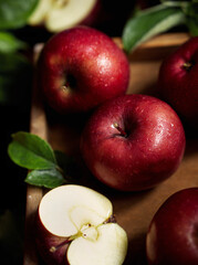 Ripe red apples in wooden box. Top view with space for your text. Ripe red apples in a wooden box. Top view with space for text. Apples whole and cut in half, apple leaves. Harvest from the garden.