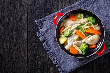 chicken vegetable soup with pasta in red pot