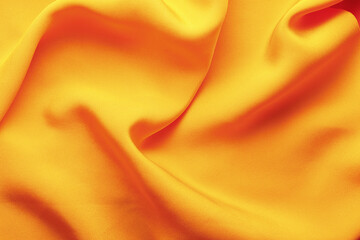 Bright orange fabric with wrinkles. Vivid fabric background with folds. The texture of the fabric. Dark background. Top view.