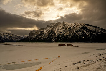 Cloudy colorful skies and winter sunset over mountain peaks at Lake Minnewanka