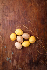 Yellow and brown DIY eggs colored with turmeric and pepper for easter celebration. Top view, copy space, vertical shot