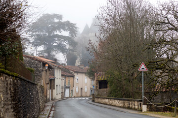 Street of Verteuil sur Charente in foggy winter day, Charente, France