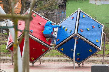 Little boy on the climbing wall of playground in Gdansk, Poland.