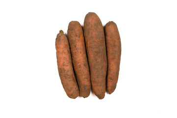 A pile of dirty carrots isolated on a white background. The concept of healthy eating.