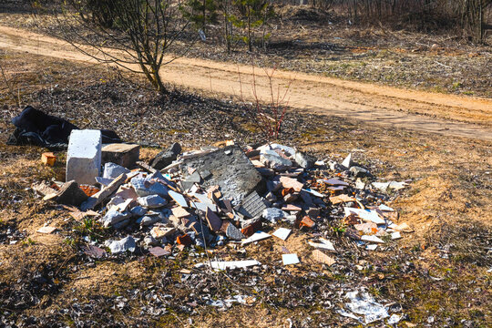The unaccountable attitude of man to nature, environmental problems. Construction waste dump near a forest road.