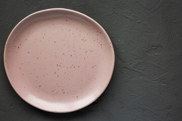 Empty ceramic pink plate on a gray background, top view. Flat lay, overhead, from above. Copy space.
