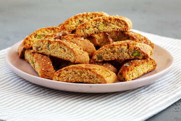 Homemade Italian Cantuccini with Pistachios and Citron on a Plate, side view. Crispy Pistachio and Citron Cookies.