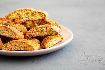Homemade Italian Cantuccini with Pistachios and Citron on a Plate, side view. Crispy Pistachio and Citron Cookies. Space for text.