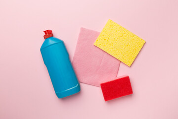 Bottle with dishwashing detergent and sponges on color background, top view