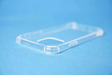 Close-up of a transparent silicone case for a smartphone on a blue background.