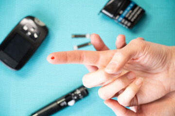 Close-up of a finger with a drop of blood to measure its sugar level.