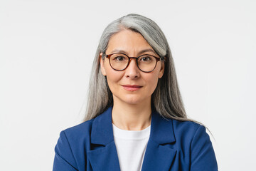 Closeup cropped portrait of a caucasian middle-aged mature businesswoman teacher freelancer CEO manager with grey hair in glasses and formal attire looking at camera isolated in white background