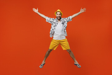 Fototapeta na wymiar Full body winner fun excited exultant jubilant young tourist man in beach shirt hat jump high with outstretched hands legs isolated on plain orange background Summer vacation sea rest sun tan concept.