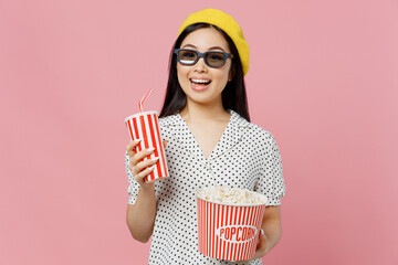 Young smiling happy cool woman in 3d glasses watch movie film hold bucket of popcorn cup of soda...