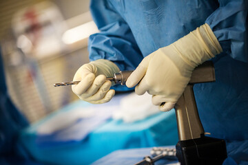 Operating room: nurse preparing a drill for fitting a knee prosthesis.