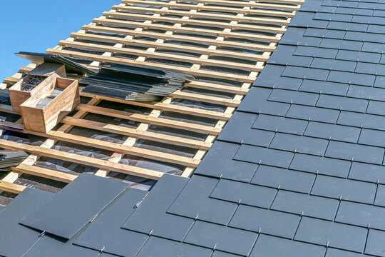 Image of a construction site covering a slate roof of a house.