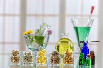 Glass jars of food supplements with essential oils and a glass mortar.