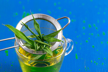 Close up of bamboo leaves above the bamboo infusion cup.