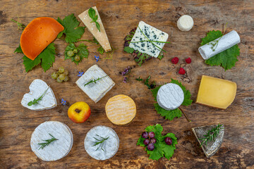 Variety of French and Dutch cheeses laid on a wooden table top view.