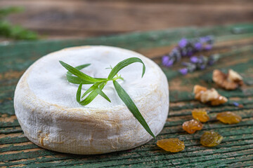 Close-up of saint-nectaire (cheese) alone on an old wooden board.