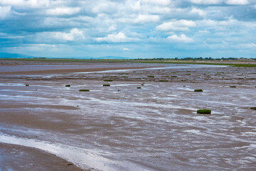 Strand mit Wolken bei Ebbe