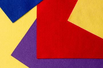Abstract colorful geometric felt texture background. Bright yellow, blue, red, purple colors felt textile for craft. Top view, flat lay