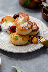 Obraz na płótnie Canvas cheese pancakes with cherry, nectarine, yougurt. breakfast table