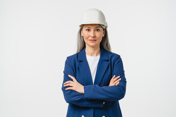 Businesswoman mature female construction worker, engineer, architect in formal suit looking at camera in protective hard hat isolated in white background. Real estate agent
