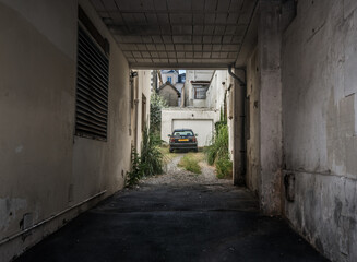 Biarritz, France - July 28 2016: Black car parked in an overgrown backyard.