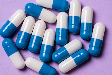 White and blue medicine pills on a table.