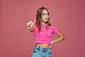 Serious child girl warning, says be careful, showing stop gesture, saying no by raised up finger, disapprove something