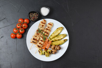 Serving of grilled chicken with vegetable garnish and potatoes. BBQ food background