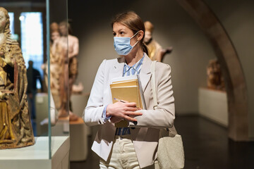 Woman considers exhibits in museum