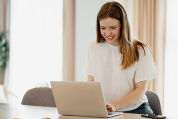 Young female freelancer online learning education at home, uses laptop and internet site