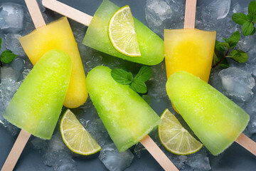 Homemade popsicles with lime juice, mint and orange ice lolly