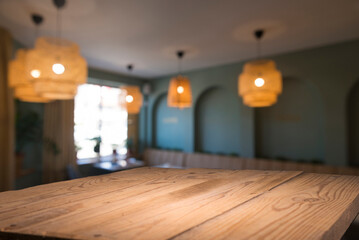 Empty wooden table top with lights bokeh on blur restaurant background.
