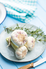 Whole garlic bulb. Fresh white garlic on blue table.