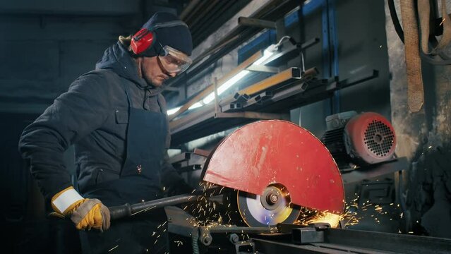 cutting of metal structures, making homemade armor plate by professional worker using a cutting machine. cutting work with smooth equipment for steel metal, iron, sparks in a heavy industry factory
