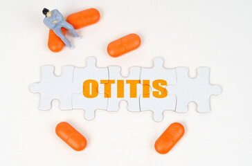On the white surface of the tablet, a miniature human figure and puzzles with the inscription - Otitis