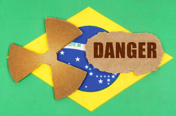 On the flag of Brazil, the symbol of radioactivity and torn cardboard with the inscription - Danger