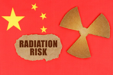 On the flag of China, the symbol of radioactivity and torn cardboard with the inscription -...