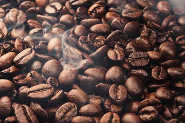 Texture of freshly roasted, ready-to-drink coffee, steam rising over the beans. Close-up, selective focus. Scene of coffee beans. Black ground coffee
