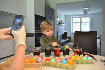 A boy coloring easter eggs. A family colors Easter eggs