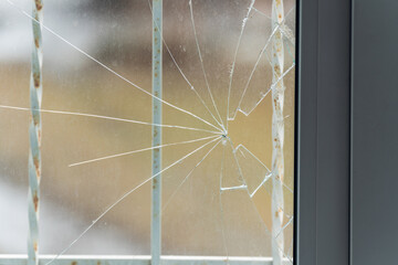 Glass broken by hooligans in a metal-plastic window, close-up - obrazy, fototapety, plakaty